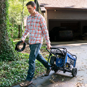 Westinghouse | WGen3600 portable generator being wheeled down a driveway.